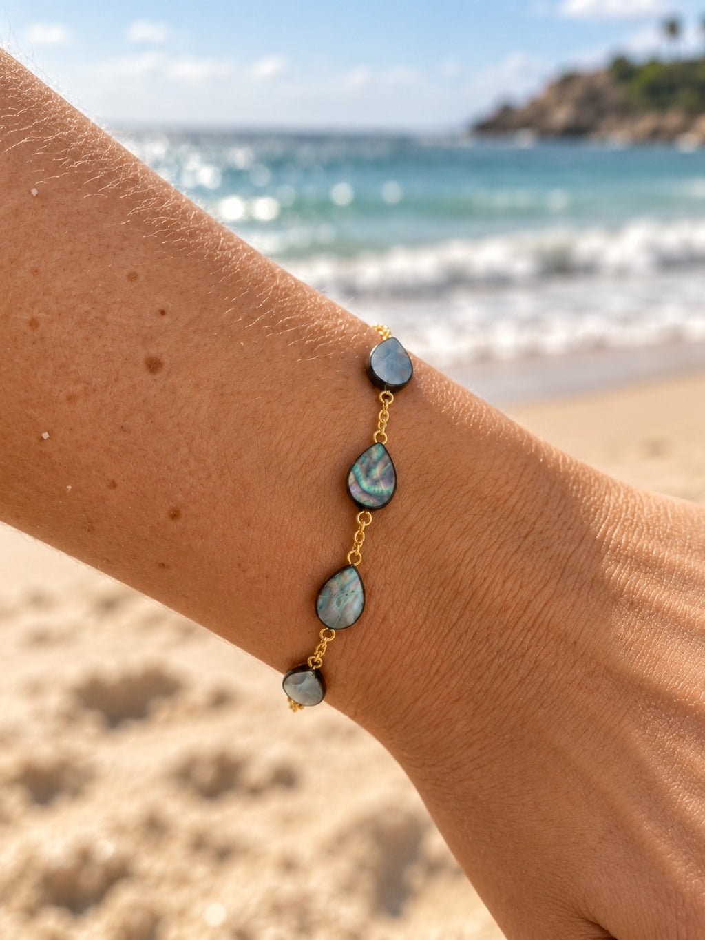 Mother of pearl shell teardrop bracelet on wrist at the beach
