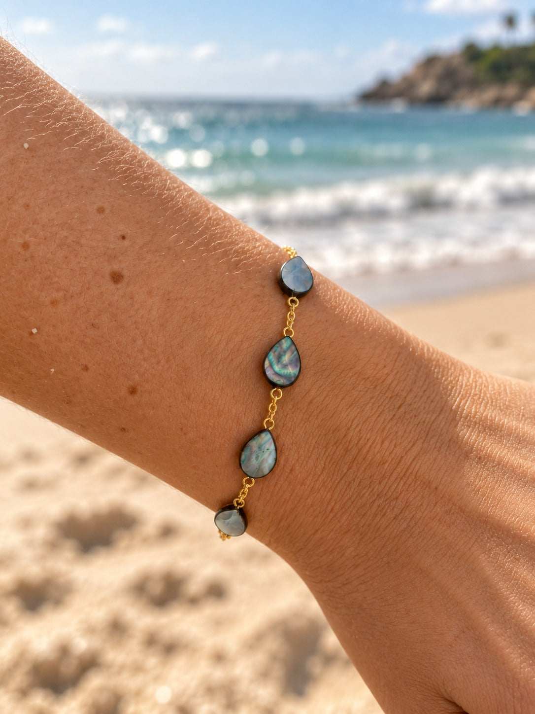 Mother of pearl shell teardrop bracelet on wrist at the beach