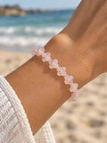 Rose quartz clover beaded bracelet on wrist at the beach