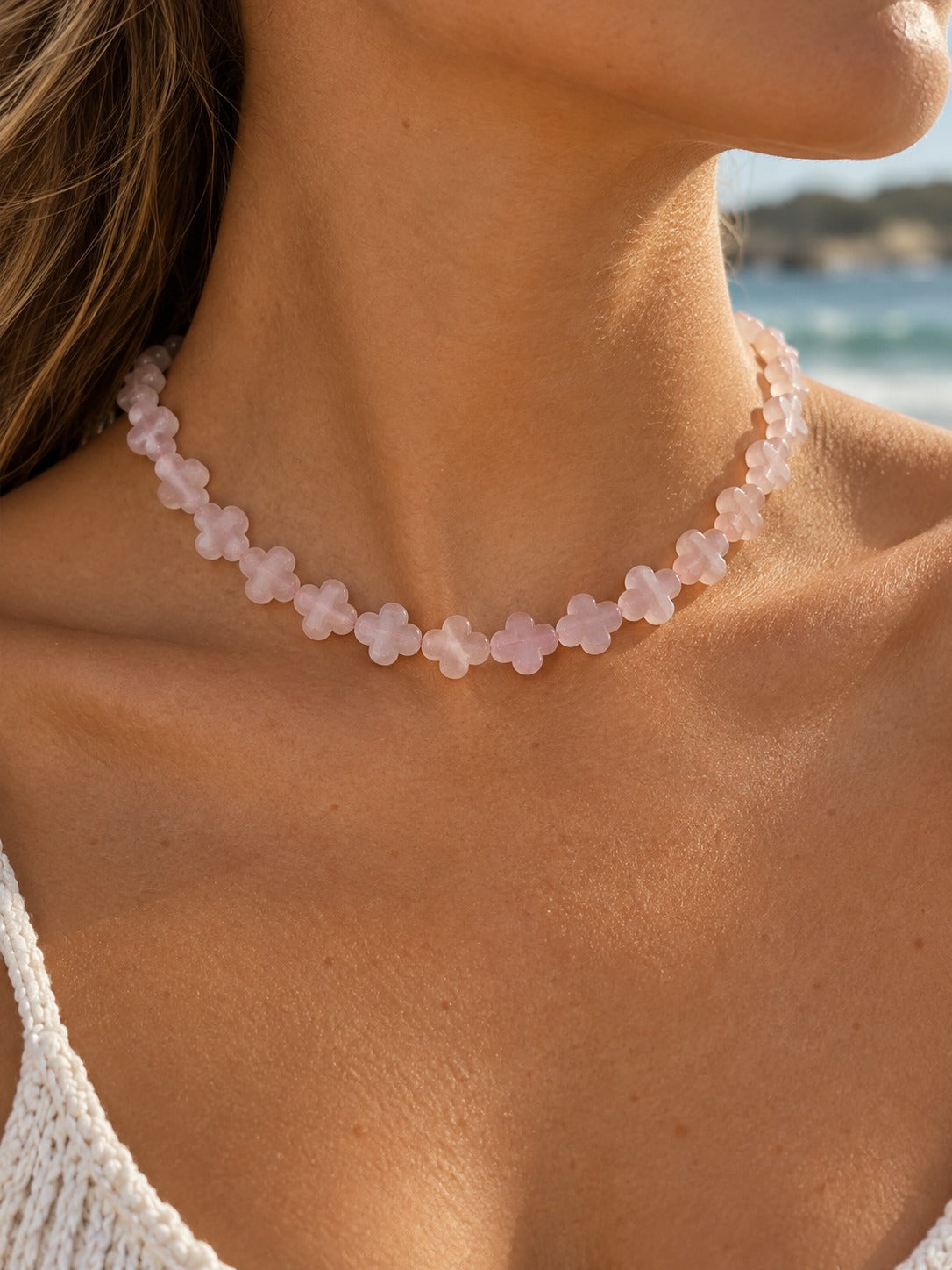 Rose quartz clover beaded necklace on model at the beach