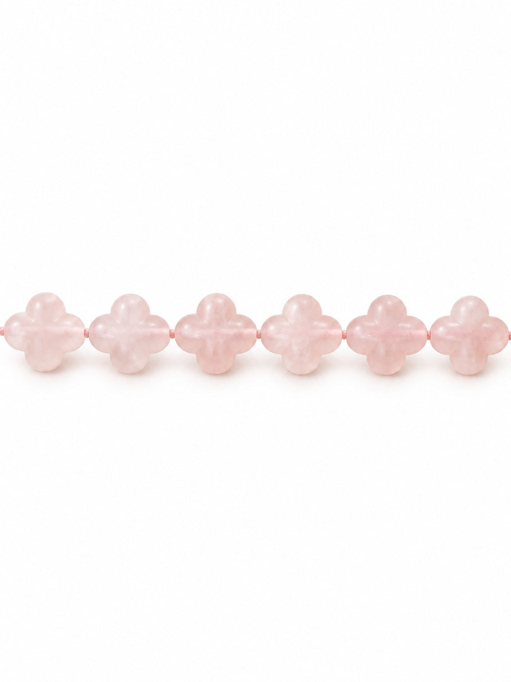 Rose quartz clover beads on white background